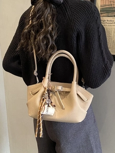 Fashionable beige litchi grain bucket bag with elegant coffee cup and tassel charm