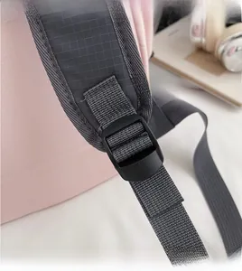 Détail du sac à dos rose avec bretelles réglables en nylon gris et boucle en plastique