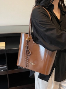 Brown large capacity tote bag in glossy leather with shoulder strap and charm