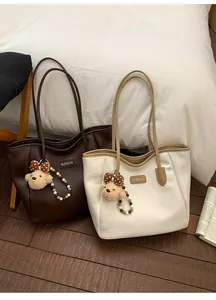 Vue détaillée de grands sacs cabas avec charms ours en peluche et étiquettes en cuir chic