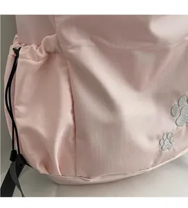 Détail du sac à dos en nylon rose avec empreintes en paillettes et poche à cordon