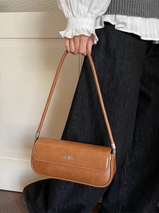 Minimalist brown leather baguette shoulder bag with silver BB logo in urban style
