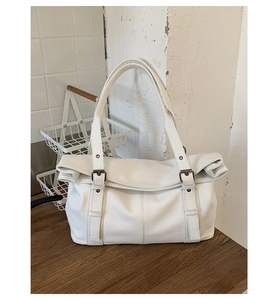 Detailed macro view of white lychee texture tote bag with metal buckles and soft handle