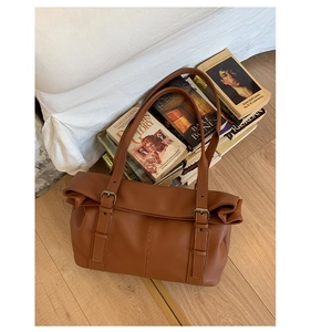 Close-up of vintage brown tote bag featuring premium pebble grain leather and metal buckle