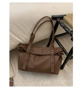 Close-up of brown lychee texture tote bag with silver buckles and large capacity