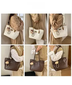 Gros plan de cabas minimalistes en beige et marron avec breloque d'ours en peluche doux