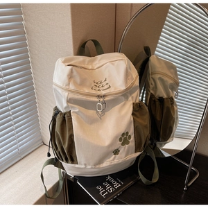 Détail d'un sac à dos grande capacité avec broderie et poches latérales à cordon