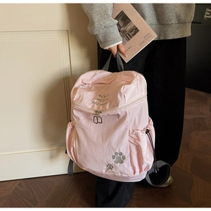 Détail du sac à dos rose avec empreintes de pattes de chat et poche latérale à cordon