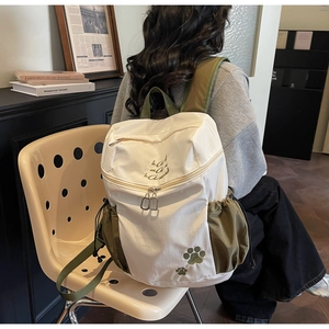 Détail du système de fermeture éclair et du contraste en toile vert olive sur le sac à dos