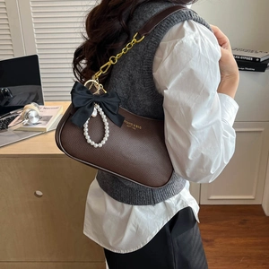 Bolso de hombro en cuero marrón oscuro con lazo de seda negra y colgante de perlas