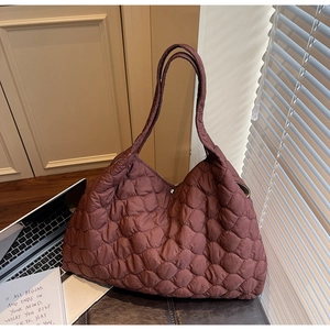 Detailed close-up of dark red quilted down tote bag with diamond stitching and soft texture