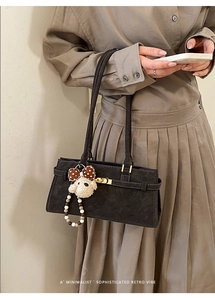 Détail du sac rétro gris foncé avec fermoir doré et pendentif chiot en peluche