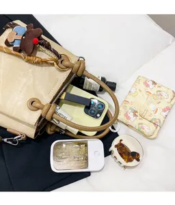 Top view of spacious khaki canvas bucket bag interior holding a phone and cosmetics