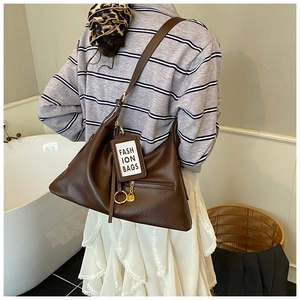 Detail view of deep coffee vintage tote bag with fashion tag and metal lock pendant