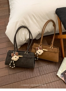 Détail de sacs Boston en daim noir et marron avec boucles en métal et pendentifs nounours
