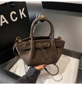 Detail van donkerbruine gewatteerde shopper met matte textuur en gouden beslag