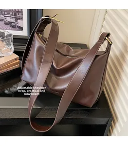 Detail view of the wide adjustable shoulder strap with golden metal buckle on tote bag