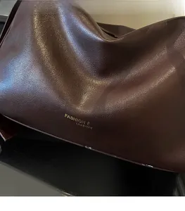 Detailed macro view of dark brown leather texture and golden embossed fashion lettering
