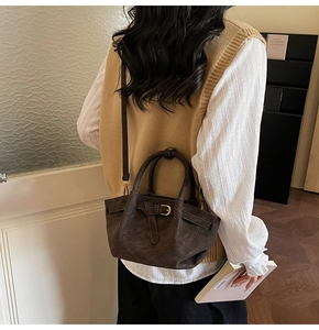 Détail du sac matelassé marron avec boucle dorée vintage et poignée arrondie