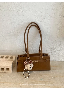 Détail du sac rétro caramel avec fermoir doré et charm de chiot en peluche mignon