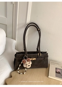 Détail du sac baguette rétro vintage en cuir suédé marron foncé avec fermoir doré