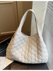 White quilted puffer tote bag with magnetic closure for women shown in office setting