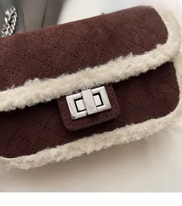 Detail of vintage brown suede crossbody bag with fleece trim and silver twist lock