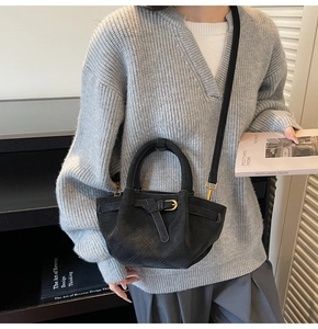 Detail van zwarte gewatteerde shopper tas met gouden gesp en verstelbare riem