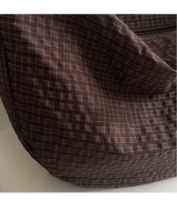 Detail of dark brown checkered nylon fabric showing soft texture and lightweight mesh pattern
