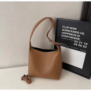 Detail of brown litchi pattern bucket bag with adjustable silver buckle shoulder strap
