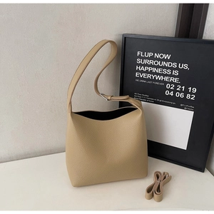 Detail view of apricot lychee pattern leather bucket bag with adjustable shoulder straps