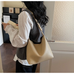 Detail showing beige lychee grain leather texture on the large hobo shoulder bag