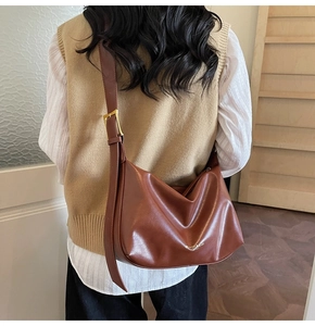 Detailed view of brown leather Hobo bag with adjustable wide strap and gold metal buckle