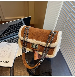 Detail of a brown suede crossbody bag with white shearling trim and diamond stitching