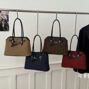 Detail of minimalist tote bags in four colors with leather trim and metal buckles