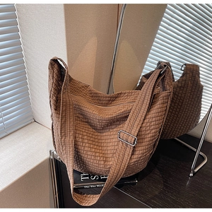 Detail of dark brown checkered hobo bag with adjustable wide strap and silver buckle