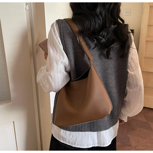 Detail of a brown lychee pattern leather Hobo bag with adjustable shoulder strap and silver buckle