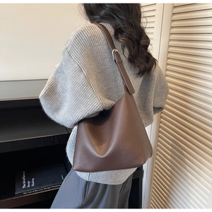 Detail of caramel brown lychee grain leather shoulder bag with adjustable strap
