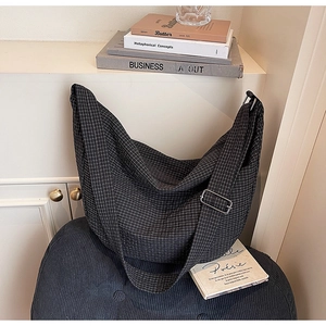 Chic black and white checkered tote bag with adjustable strap and silver metal buckle