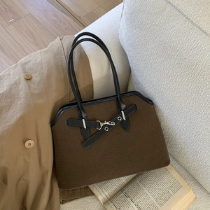 Detail of vintage canvas tote with black leather trim and silver metal hardware accents