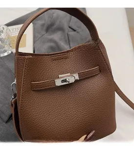 Detail of brown litchi leather handbag featuring silver twist lock and sturdy handle