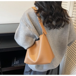 Close-up of brown lychee-patterned leather bucket bag showing large capacity and soft texture