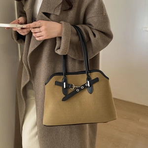 Detail of retro tote bag with khaki texture, black leather trim and silver buckles