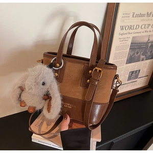 Détail du sac seau vintage en cuir marron avec pendentif lapin en peluche et anses