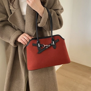 Detail of red tweed shoulder bag with black leather trim and silver metal buckle closure