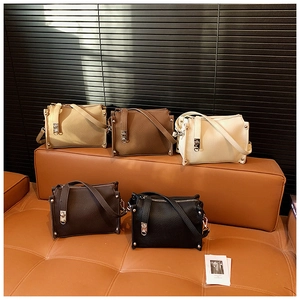 Detailed view of five textured faux leather handbags with silver hardware on a leather sofa