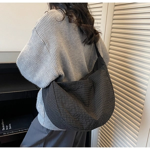 Detail of minimalist black and white checkered crossbody bag with adjustable wide strap