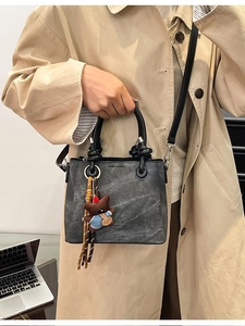 Vintage dark gray bucket bag with top handle and bear charm for urban commuting