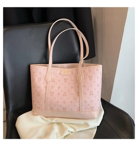 Detail of pink tote bag showing cute rabbit prints and gold metal brand name plaque