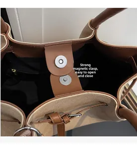 Detail of canvas tote bag showing silver magnetic snap closure and black interior lining